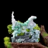 Carved jade sculpture with greenery on wooden base.