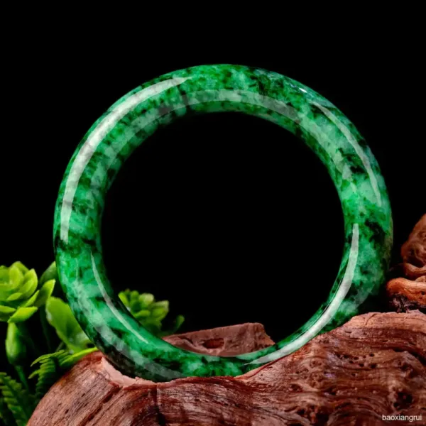 Green jade bangle on a wooden surface.