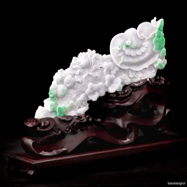 Jade carving of clouds on wooden stand.