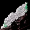 Intricate jade dragon sculpture on stand.