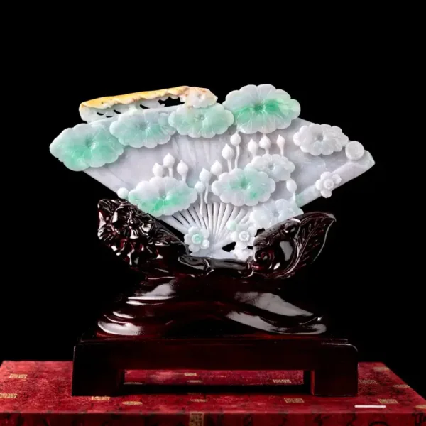 Intricate jade flower carving on wooden base.