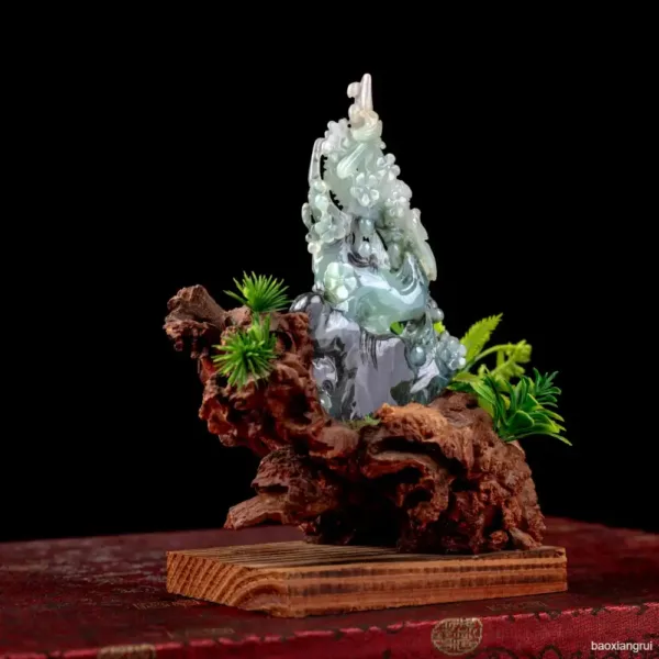 Jade carving on wood base with greenery decoration.