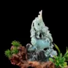 Jade figurine with flowering plants on wood base.