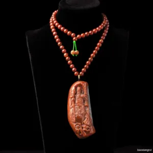 Carved amber pendant on beaded necklace.