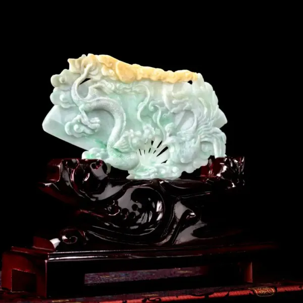 Carved jade dragon sculpture on wooden stand.