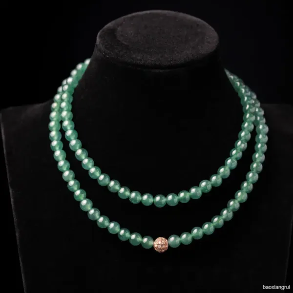 Double strand jade necklace with central diamond bead.