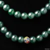 Green jadeite beads with decorative gold clasp.