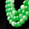 Green jade beads necklace on black background.