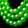 Green jade beads close-up on black background.