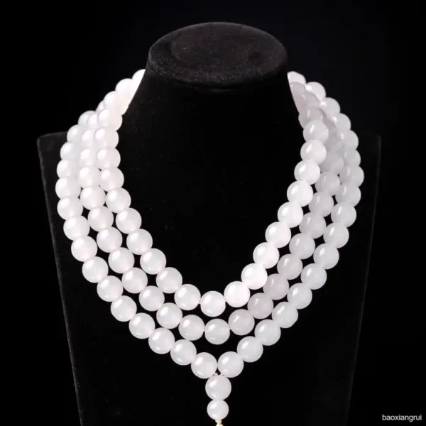 White pearl necklace on black display stand.