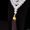 White bead necklace with brown tassel detail