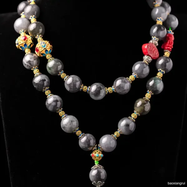 Beaded gemstone necklace with gold accents and charms.