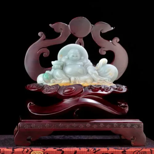 Jade laughing Buddha statuette on dark background.