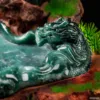 Carved jade dragon sculpture on wooden base.