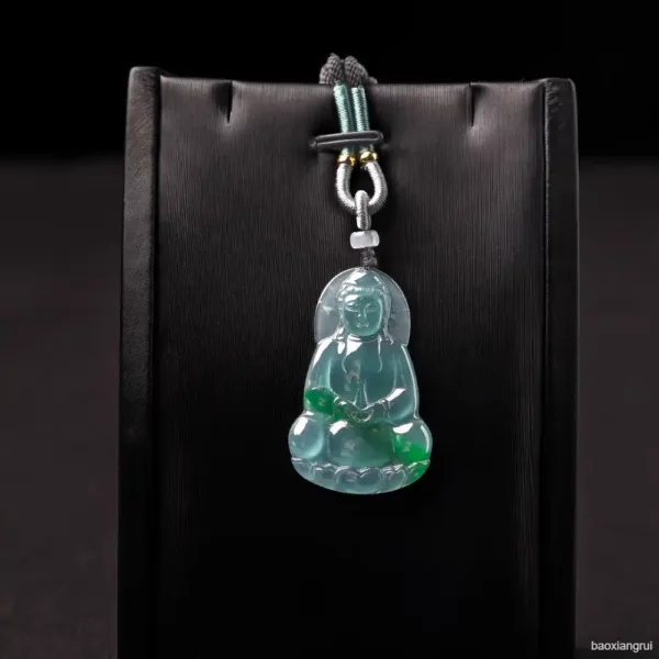 Jade Buddha pendant on black background.