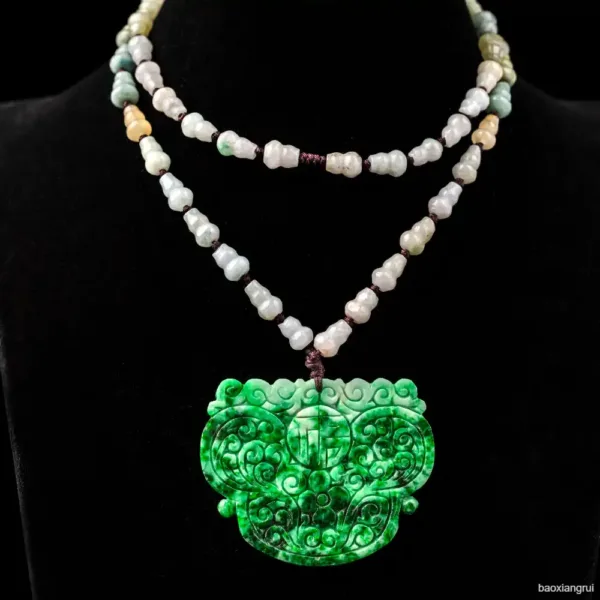 Green jade necklace with intricate pendant on black background.