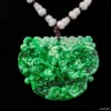 Carved jade pendant on black background.