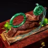 Carved jade bangle and necklace on wooden display.