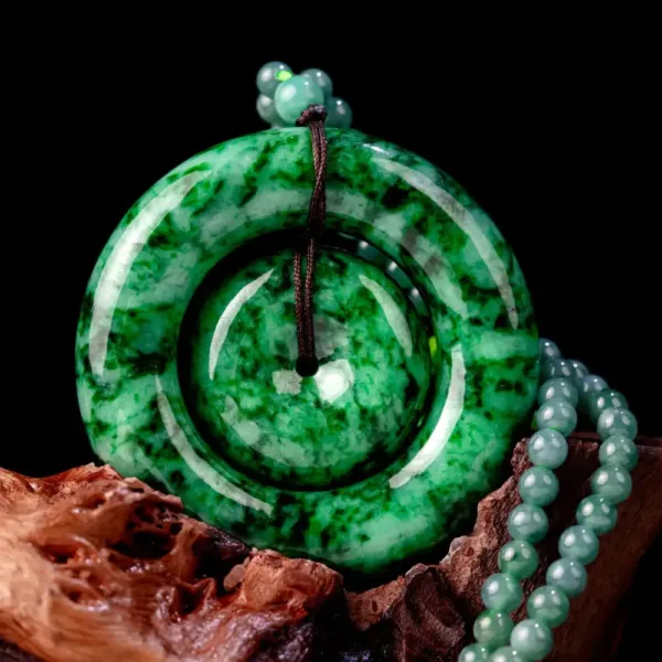 Jade pendant and beads on wood against black background.