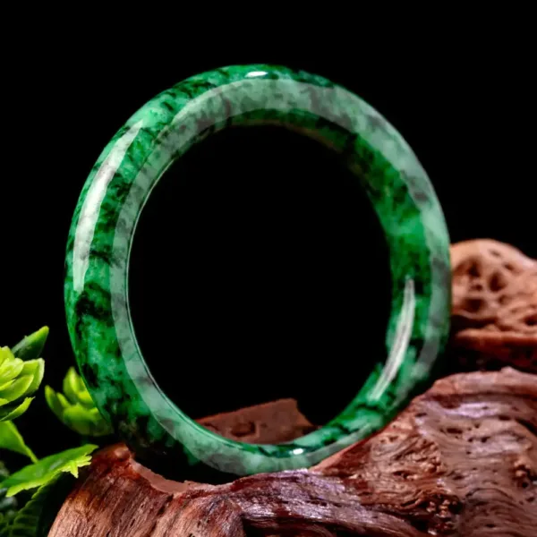 Polished jade bangle on wooden surface.