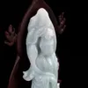 Carved jade figurine on dark background.