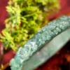 Close-up of a green crystal bracelet on natural background.