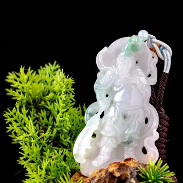 Jade carving pendant with greenery on black background.