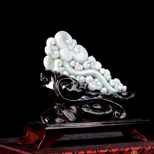 Carved jade sculpture on black background.